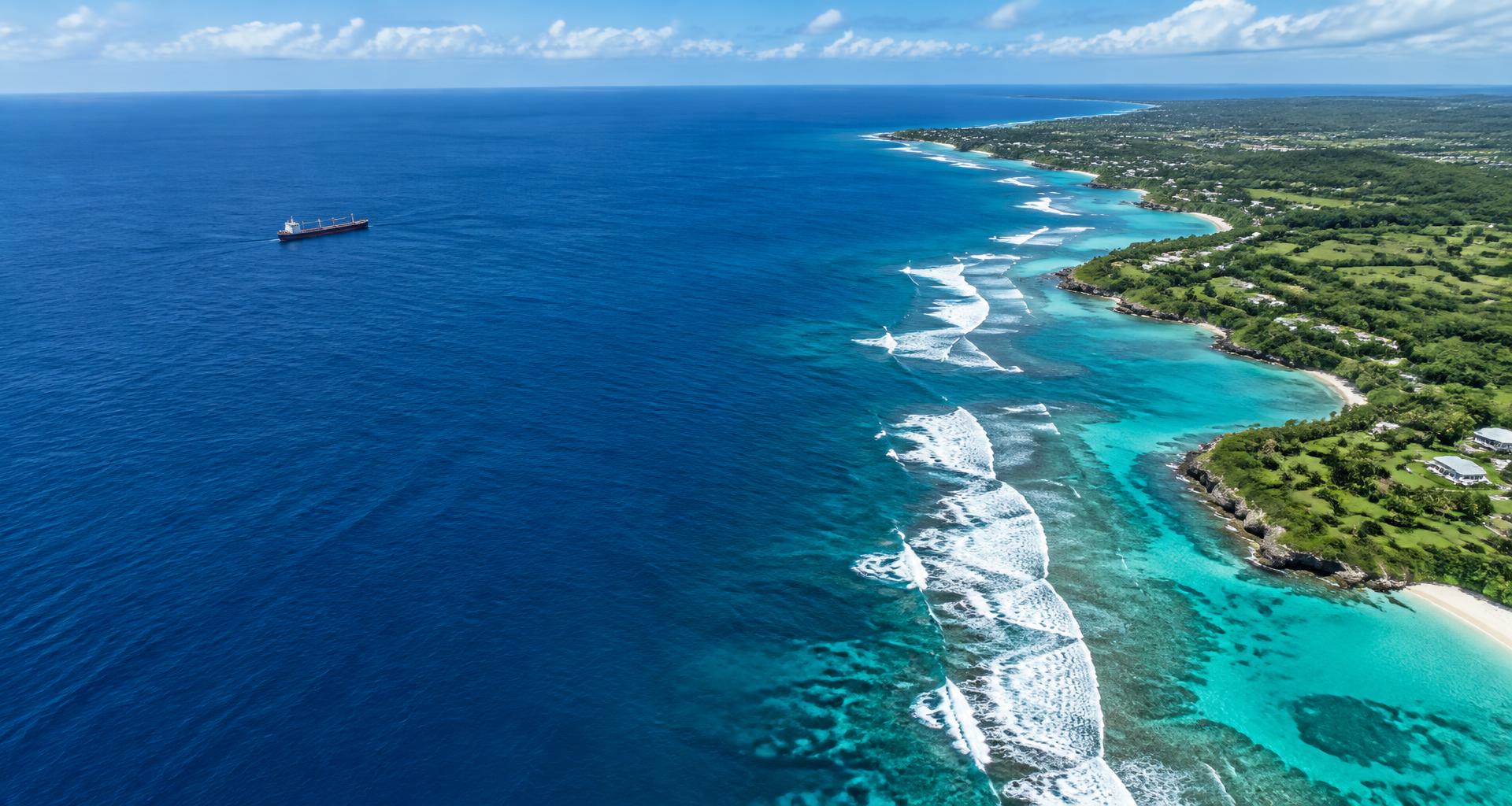 Aerial view of a Caribbean coastline, shipping waters, and island infrastructure